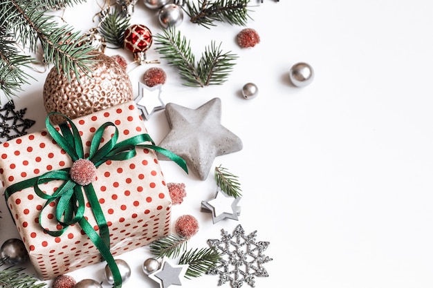 Christmas composition. Gifts, fir tree branches, red decorations on white wall. Winter, new year concept. Flat lay, isometric, space for text