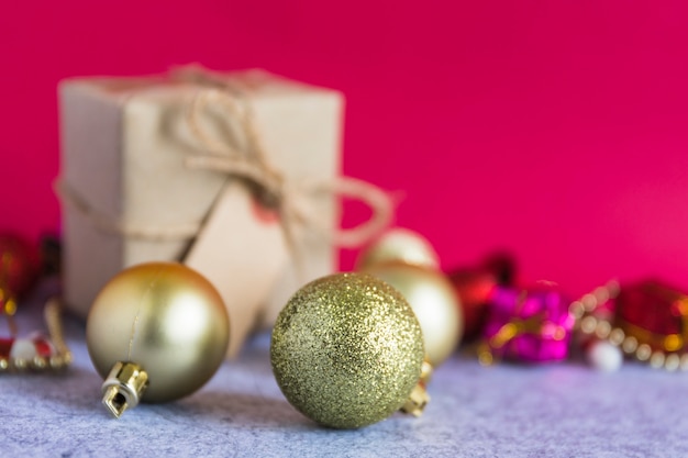 Free photo christmas composition of gold baubles with small gift box