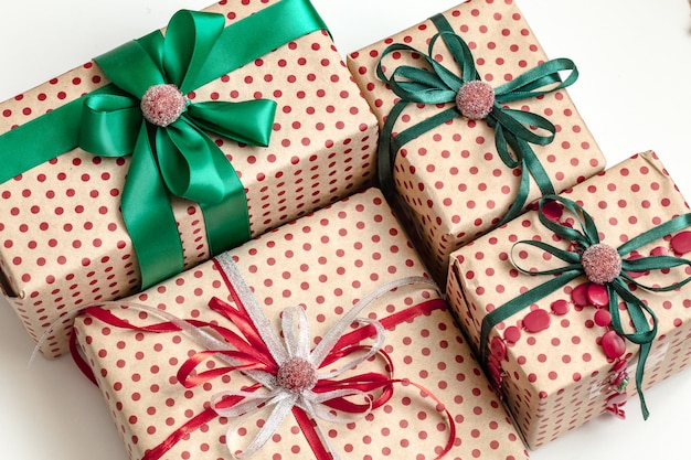 Christmas composition of various gift boxes wrapped in craft paper and decorated with satin ribbons. Top view, flat lay.