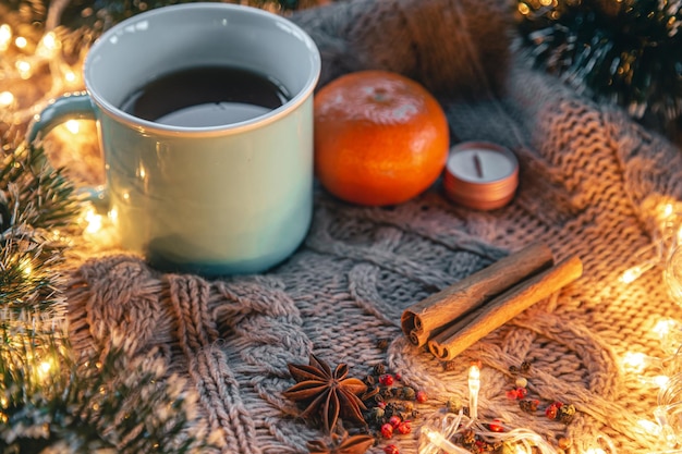 Free photo christmas composition with a cup of tea spices on a knitted element