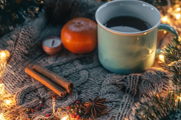 Free photo christmas composition with a cup of tea spices on a knitted element