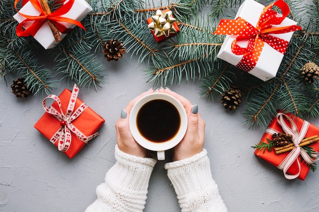 Free photo christmas composition with hands holding coffee and presents