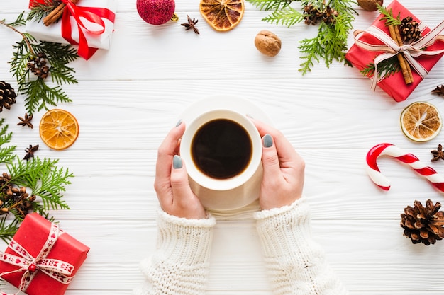 Christmas composition with hands touching coffee cup