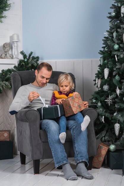 Christmas concept with family on couch with presents