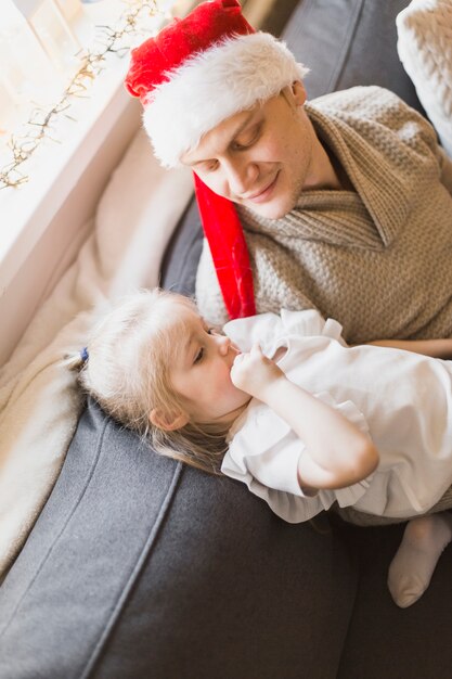 Christmas concept with father and daughter on couch