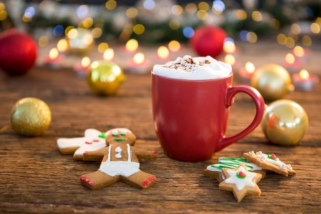 Free photo christmas cookies next to a red cup