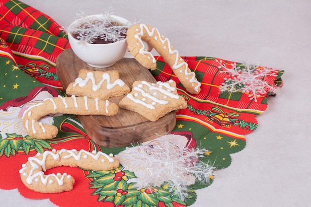 Christmas cookies with aroma tea in cup on white table.