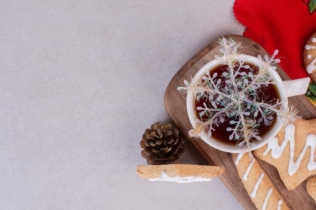 Christmas cookies with aroma tea in cup on white table.