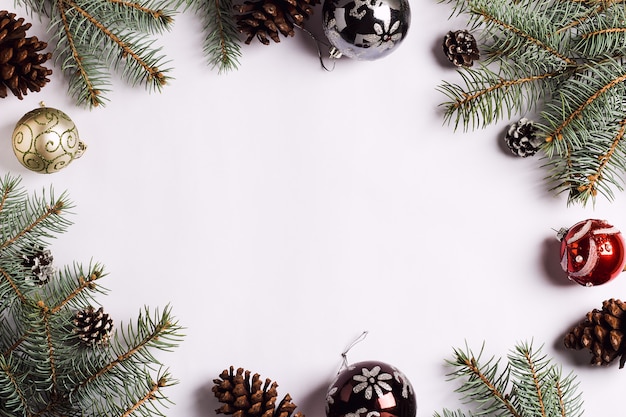 Christmas decoration composition pine cones balls spruce branches on white festive table