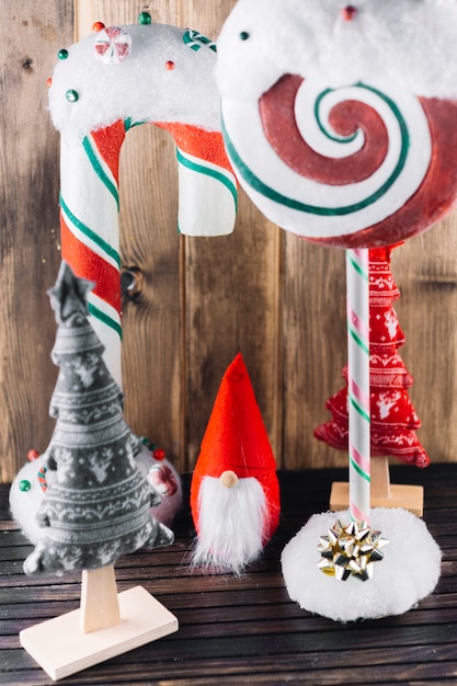 Free Photo christmas elf with big candies on table 