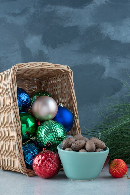 Christmas festive balls with a blue plate of nuts. High quality photo