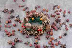 Free photo christmas festive wreath with pinecones and star anise on marble background.