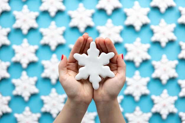 Christmas gingerbread in the shape of a snowflake in female hands