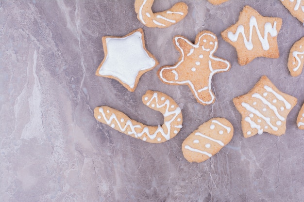 Free Photo christmas gingerbreads in different shapes on stone surface