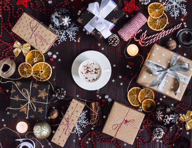 Free photo christmas holiday coffee cup drink gift box on decorated festive table with pine cones candy cane candle