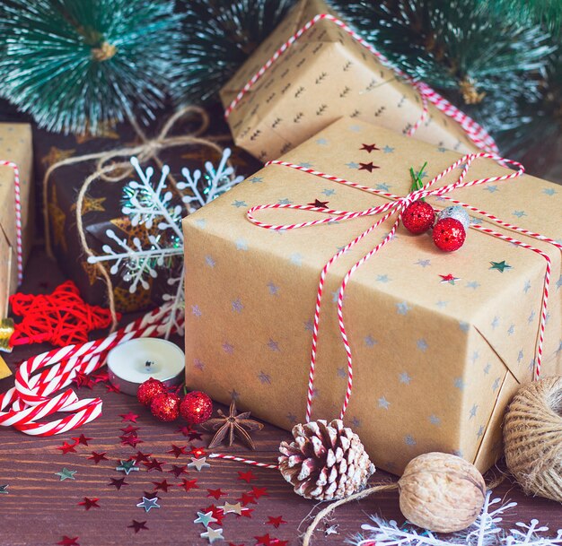 Christmas holiday gift box on decorated snow festive table with pine cones fir branches