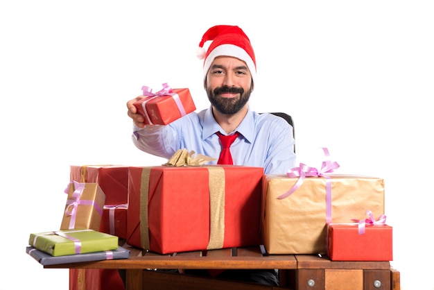 Christmas man in his office with several gifts