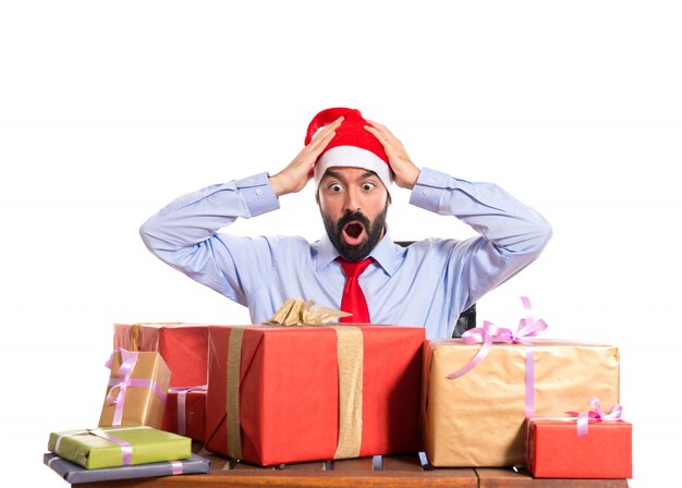 Christmas man in his office with several gifts