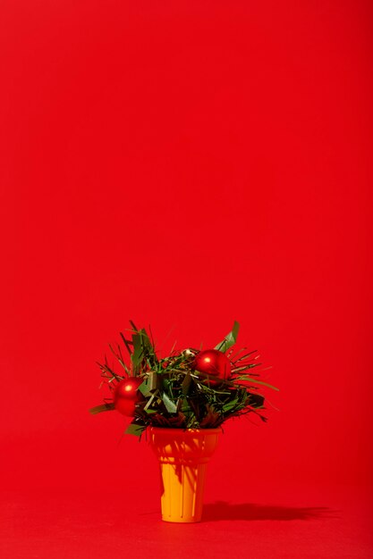 Christmas ornaments in ice cream cone on red wall