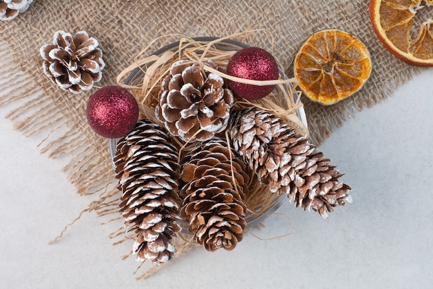 Free photo christmas pinecones with dried oranges on sackcloth. high quality photo