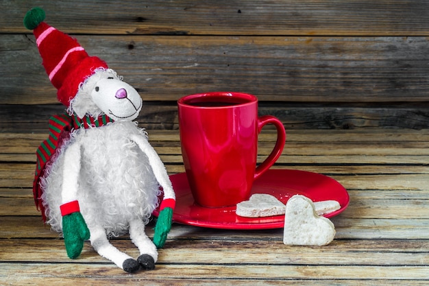 Free photo christmas, red cup with coffee and dessert on wooden table