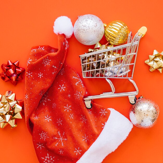 Christmas shopping concept with close up of cart and hat