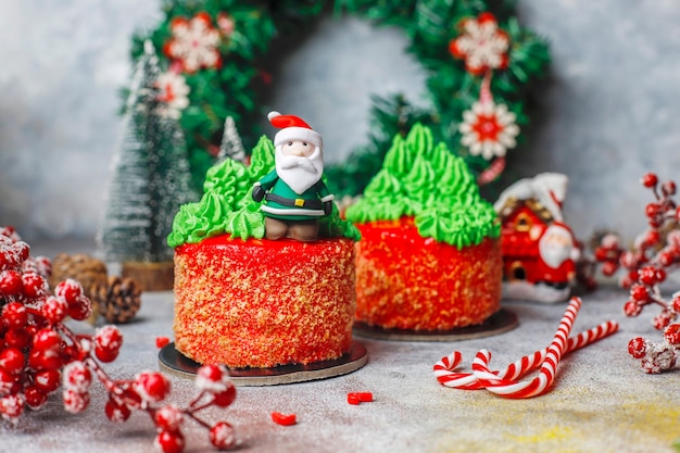 Christmas small cake decorated with sweet figures of christmas tree,santa claus and candles.