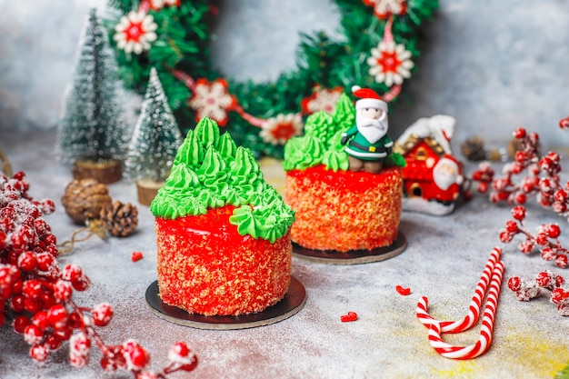 Christmas small cake decorated with sweet figures of christmas tree,santa claus and candles.