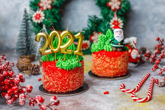 Christmas small cake decorated with sweet figures of christmas tree, santa claus and candles.