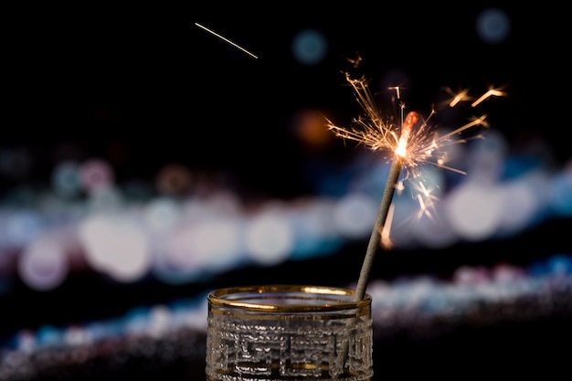 Christmas sparkler on dark background with bokeh lights