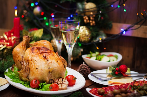 Christmas table served with a turkey, decorated with bright tinsel and candles.