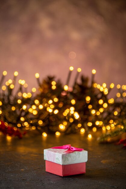 Christmas texture festive lights with little gift box on the isolated dark background