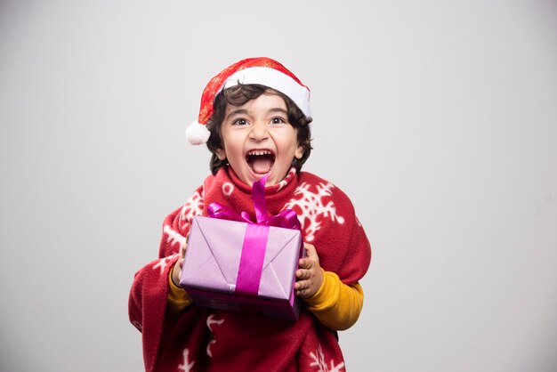 Christmas time with happy child holding gift box