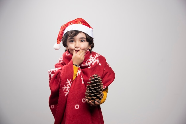 Free photo christmas time with kid disguised in red santa claus uniform