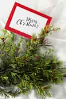 Free photo christmas tree branches on white cloth with christmas card mock-upm