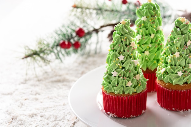 Free photo christmas tree cupcakes isolated on white background