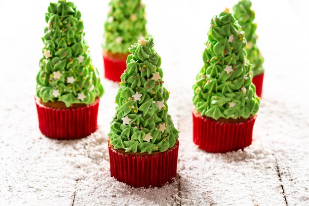 Christmas tree cupcakes on wooden table