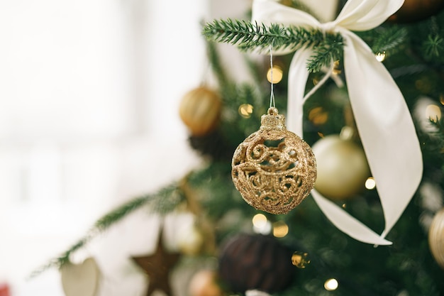 Free Photo christmas tree decorated with white and golden balls close up