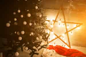 Free photo christmas tree with lights and star in a loft room