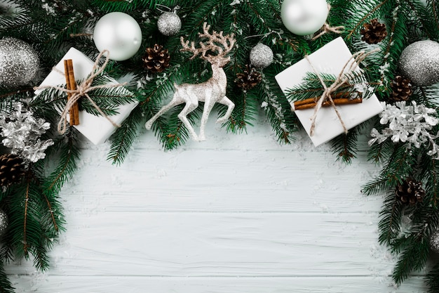 Free photo christmas twig with silver deer and present boxes