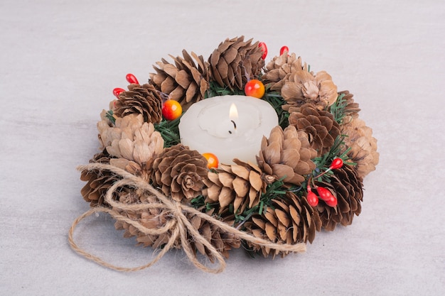 Free Photo christmas wreath and candle on white surface