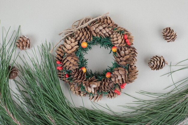 Christmas wreath and pinecones on beige surface