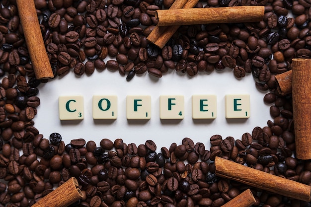 Free photo cinnamon and coffee beans around writing