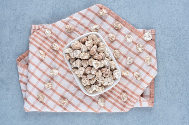 Cinnamon confectionery in the bowl on the towel, on the marble table. 