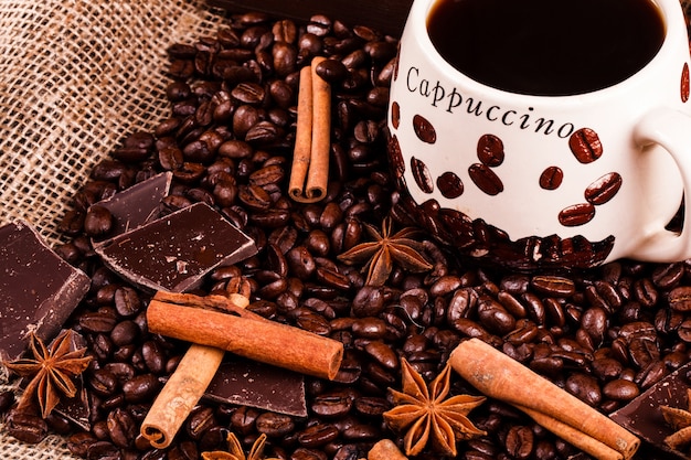 Free Photo cinnamon and other species lie on coffee beans before a cup