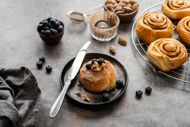 Free photo cinnamon roll with blueberries high angle