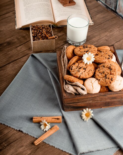 Cinnamon sticks and a cookie box on a blue tablecloth