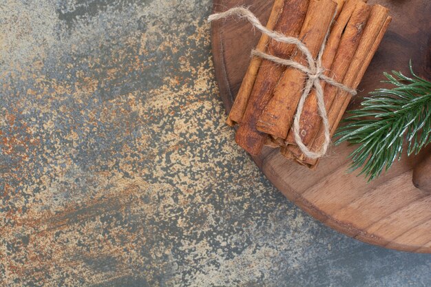 Cinnamon sticks in rope on marble background. High quality photo