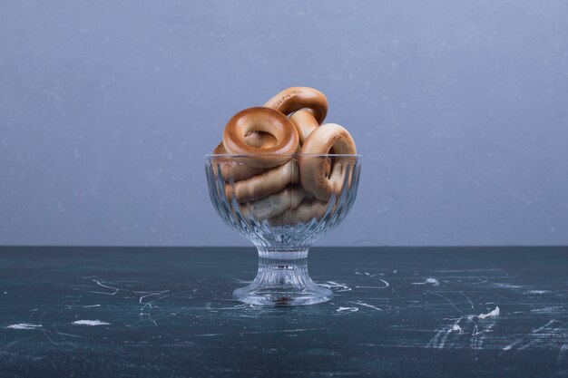 Free photo circle cookies in a glass cup in the middle of the table.