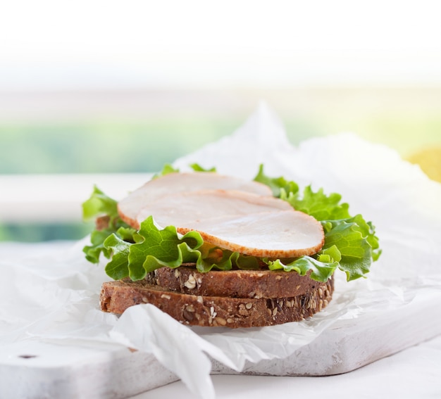 Free photo circular meat piece on top of lettuce and bread